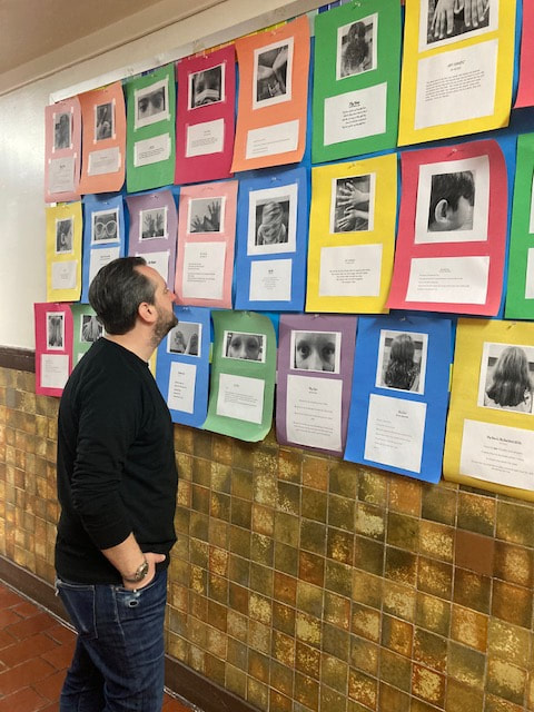 A Parent reading the student's work on PS118 spirit day.